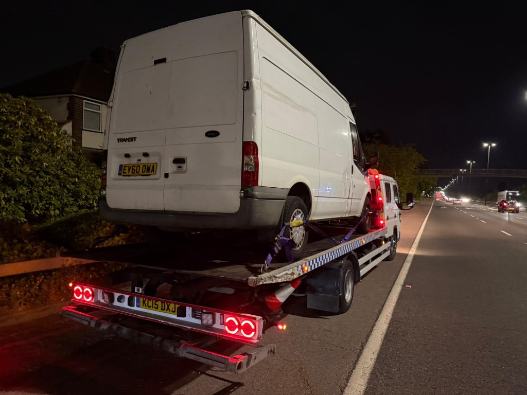 Ford Transit van recovered on flatbed at night